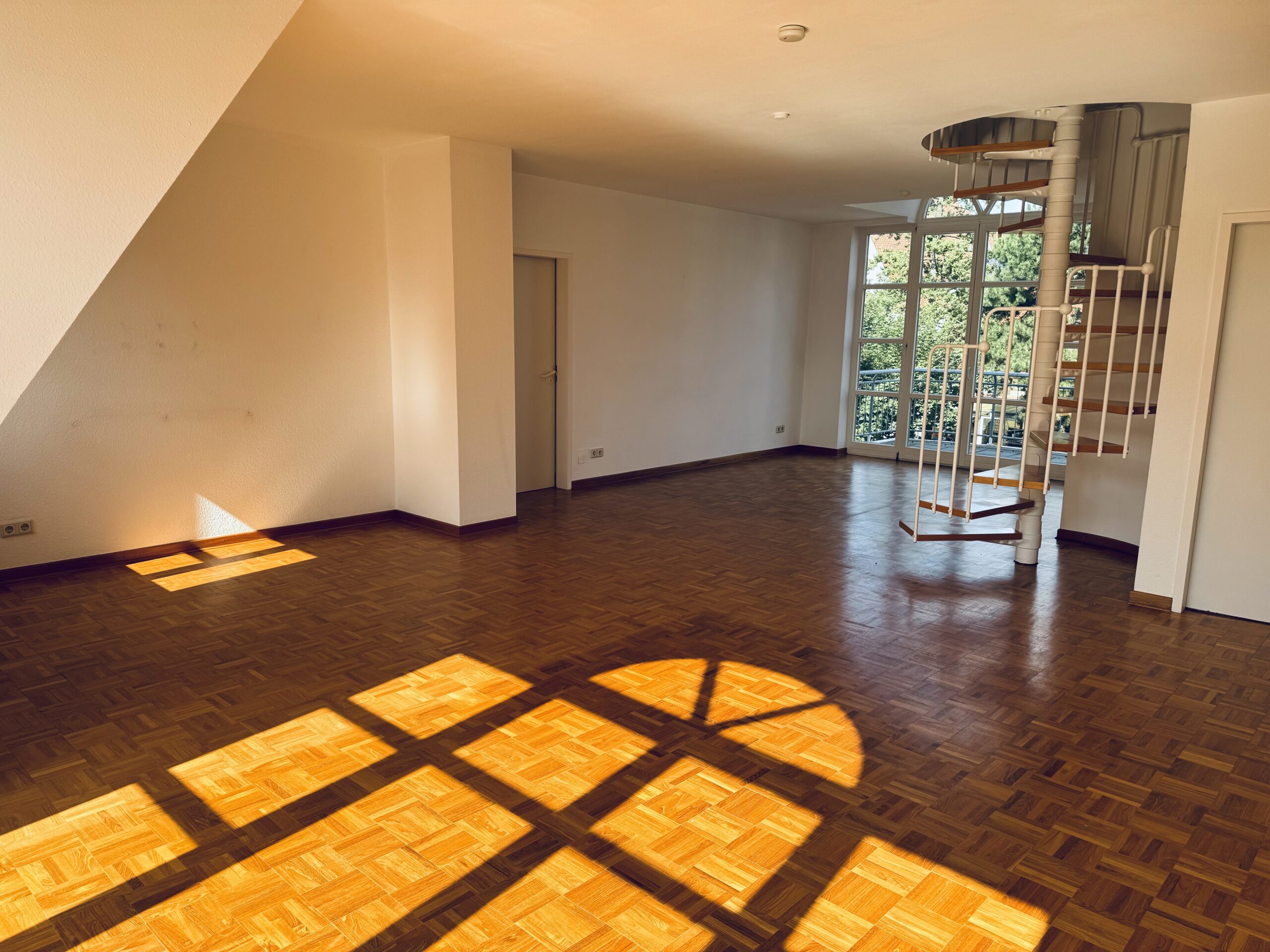 Wohnzimmer mit Stäbchenpakett und Wendeltreppe