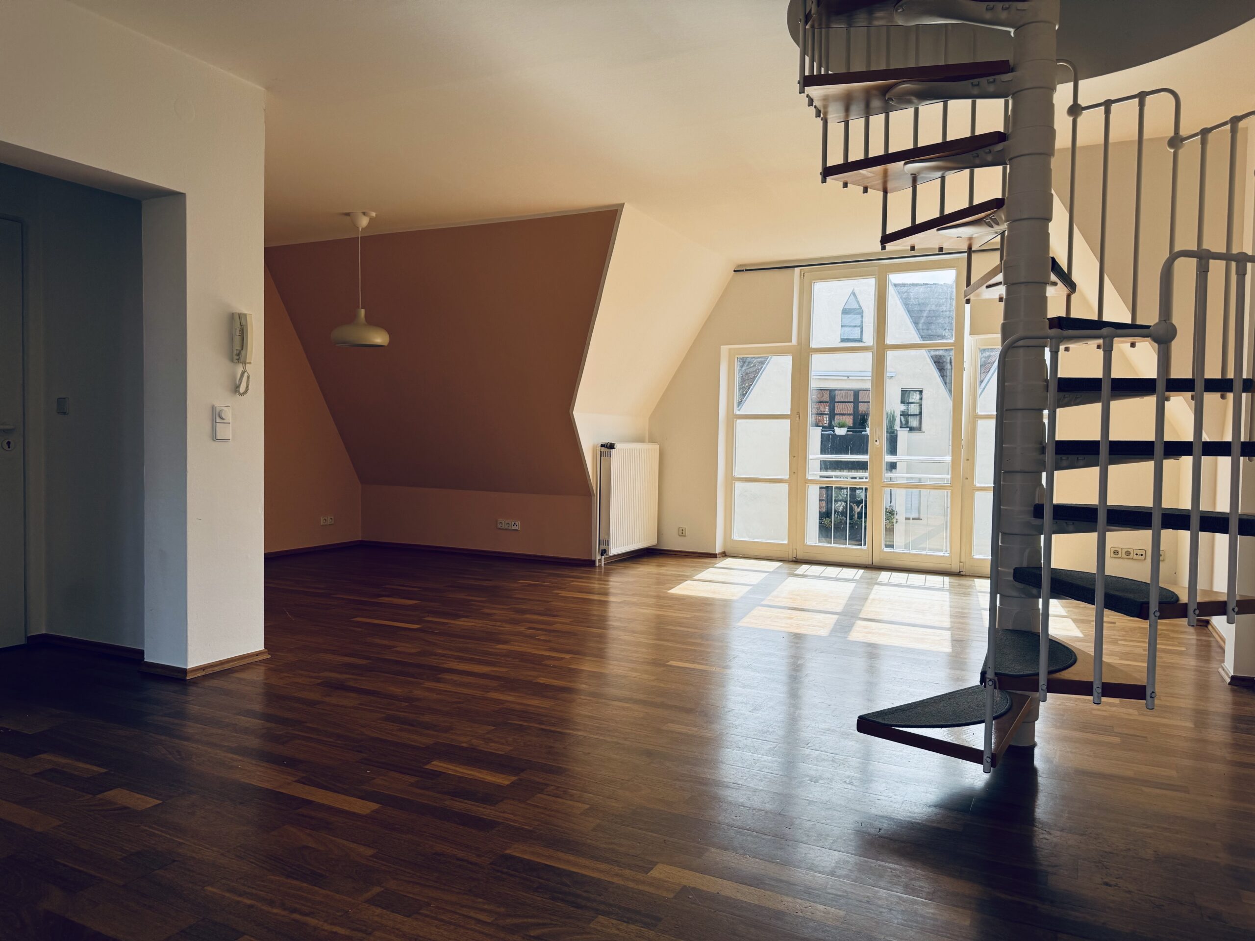 Wohnzimmer mit Holzboden und Wendeltreppe